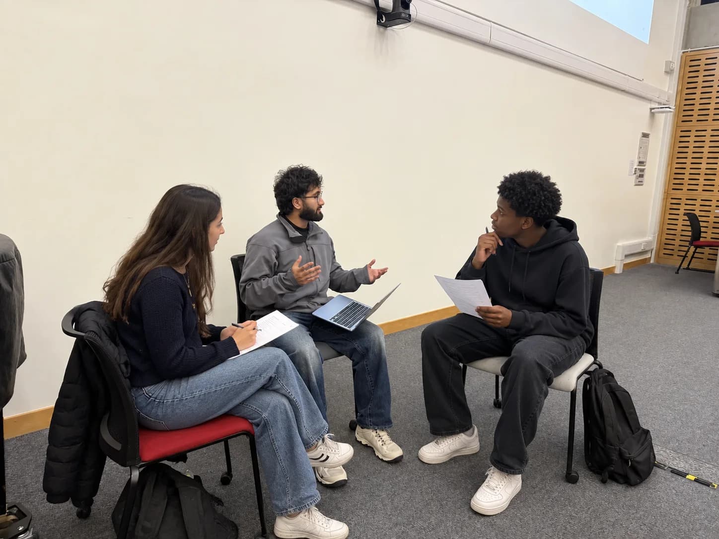Tutor and students discussing university choices and application notes